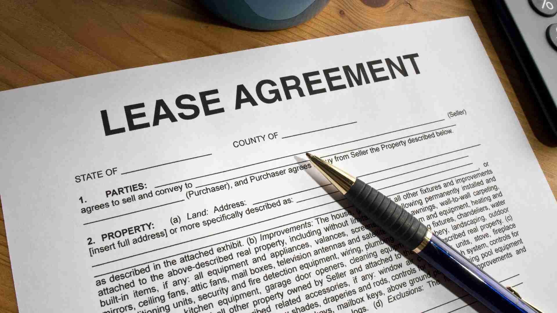 An unsigned lease agreement on a table with a pen.